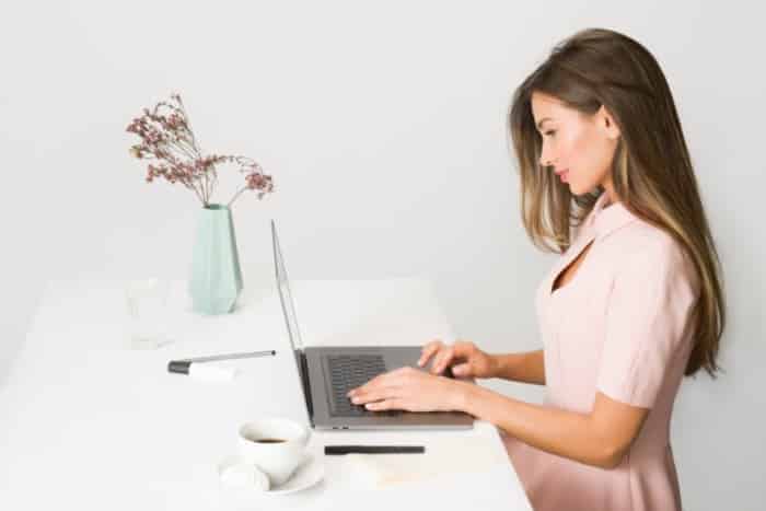 Woman Writing Using a Laptop